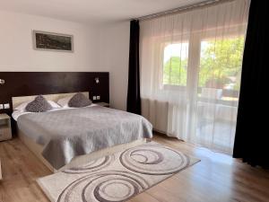 a bedroom with a bed and a large window at Casa Cenţiu in Bran
