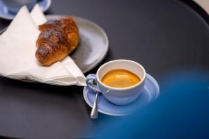 a plate with a cup of coffee and a pastry at Moro Inn in Korčula