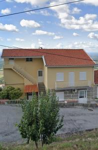 een groot geel huis met een rood dak bij Casas do Castelo in Aldeia da Serra