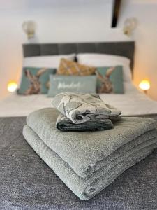 a pile of towels sitting on top of a bed at Britannia inn in Sherborne