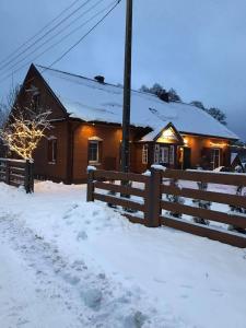 a house with a fence in the snow at STACJA RUDA in Złota Wieś