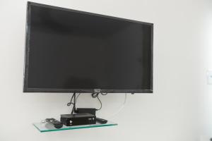 a flat screen tv sitting on top of a table at Kitnet Central in Arraial do Cabo