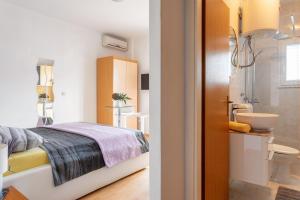 a bedroom with a bed and a bathroom at Apartments Dobrila in Hvar