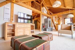 a living room with two trunks and a tv and a chair at Zentrale Penthouse im Haus Padrun in Arosa