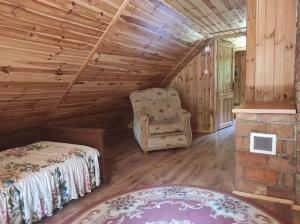 um quarto com uma cama e uma cadeira num sótão em Domek w lesie em Czerce