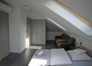 1 dormitorio con cama blanca y sofá en Reza en Bełchatów