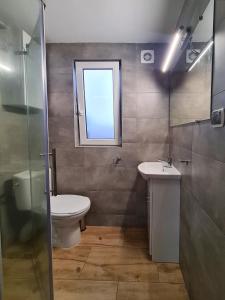 baño con aseo y lavabo y ventana en Domek Jezioro Białe Okuninka Centrum 250m molo, en Okuninka