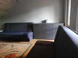 sala de estar con sofá azul y cómoda en Domek Jezioro Białe Okuninka Centrum 250m molo, en Okuninka