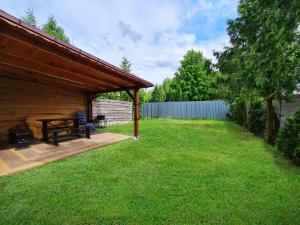 patio trasero con terraza de madera y mesa de picnic en Domek Jezioro Białe Okuninka Centrum 250m molo, en Okuninka