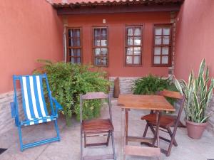 2 Stühle und ein Tisch vor einem Haus in der Unterkunft YOUNG (Praias de Dunas- Praia do Forte) -Aconchegante, compacto e super confortável. PRÓXIMO DE TUDO in Cabo Frio