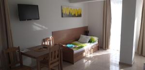 a room with a couch and a table and a television at Apartamenty Planeta 105, 108 Mielno in Mielno