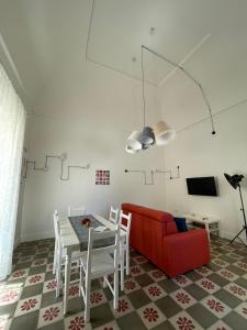 sala de estar con sofá rojo y mesa en Le Fate Ignoranti - La Terrazza su Nardò, en Nardò