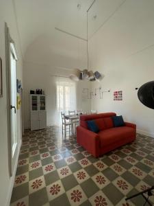 sala de estar con sofá rojo y mesa en Le Fate Ignoranti - La Terrazza su Nardò, en Nardò
