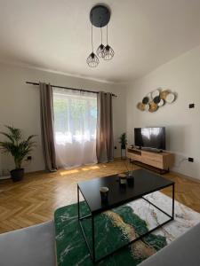 a living room with a table and a tv at Panda apartmán Frýdštejn in Frýdštejn