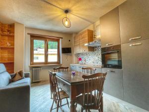 a kitchen with a table and chairs in a kitchen at Il nido dello Chaberton in Cesana Torinese