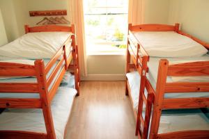 a room with three bunk beds and a window at The Eagles Bunkhouse in Betws-y-coed