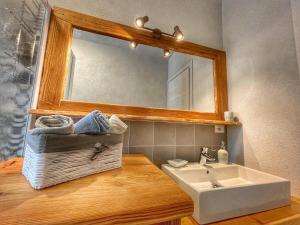 ein Bad mit einem Waschbecken und einem Spiegel in der Unterkunft Il nido dello Chaberton in Cesana Torinese