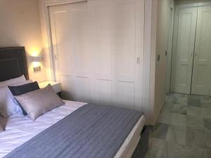 a bedroom with a large bed and a closet at Apto EN JARDINES DEL PUERTO in Marbella
