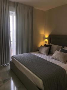 Un dormitorio con una cama grande y una ventana en Apto EN JARDINES DEL PUERTO, en Marbella