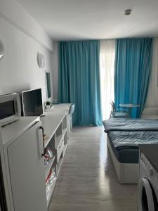 ein Krankenhauszimmer mit einem Bett und einem TV in der Unterkunft Camera de închiriat Blaxy Premium Resort in Olimp