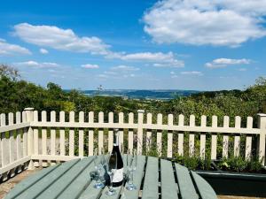 a picnic table with a bottle of wine and glasses at The Stables - Luxury Holiday Cottage in Welsh Newton Common