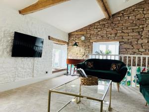 a living room with a stone wall at The Stables - Luxury Holiday Cottage in Welsh Newton Common