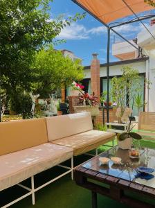 un patio con sofá y mesa en Alemar Bed & Breakfast en Mondello