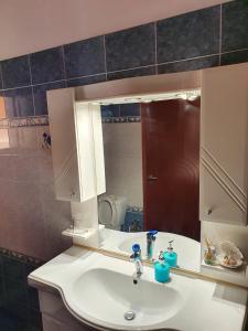 La salle de bains est pourvue d'un lavabo et d'un miroir. dans l'établissement Chania Casa Portokali, à Perivólia