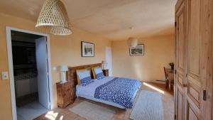 a bedroom with a bed with a blue comforter at Les Tournesols in Mallemort