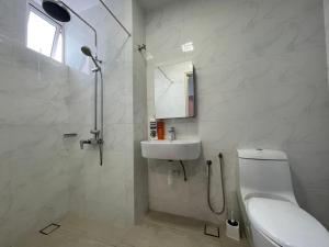 a white bathroom with a toilet and a sink at Delight Homestay Twin Galaxy Studio Room in Johor Bahru +99 photos