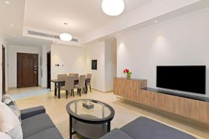 sala de estar con sofá y TV de pantalla plana en TIME Moonstone Hotel Apartments en Fujairah