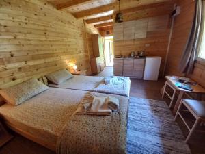 a bedroom with two beds in a wooden room at Vila Montana in Dobrilovina
