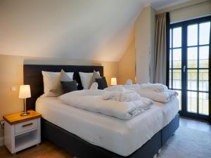 Ein Bett oder Betten in einem Zimmer der Unterkunft Reetland am Meer - Luxus Reetdachvilla mit 3 Schlafzimmern, Sauna und Kamin F18