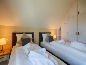 Ein Bett oder Betten in einem Zimmer der Unterkunft Reetland am Meer - Luxus Reetdachvilla mit 3 Schlafzimmern, Sauna und Kamin F18