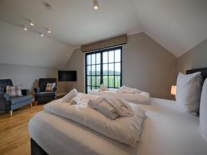 a large bedroom with two beds and a large window at Reetland am Meer - Superior Reetdachvilla mit 2 Schlafzimmern F25 in Dranske +15 photos