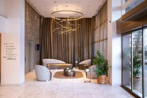 a lobby with chairs and a table and a chandelier at Hôtel du Port in Nogent-sur-Marne