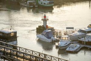 a group of boats docked at a dock with a lighthouse at Hôtel du Port in Nogent-sur-Marne