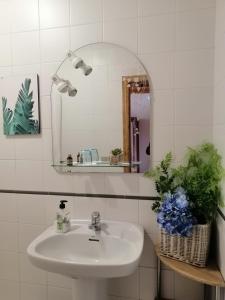 Baño blanco con lavabo y espejo en Casa Licerio, en Samos