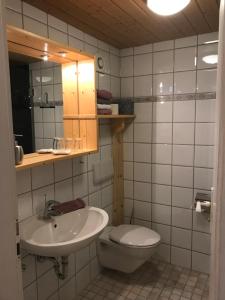 a bathroom with a sink and a toilet and a mirror at Haus Petra in Oberjoch