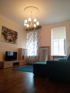 a living room with a couch and a tv and a chandelier at DICTUMFACTUM RESIDENCE 1BedRoom in Tallinn