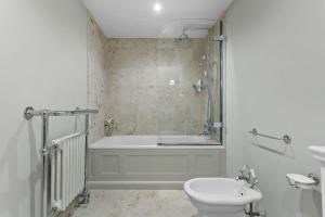 a bathroom with a bath tub and a toilet at Poplar Cottage, Budleigh Salterton in Budleigh Salterton +28 photos