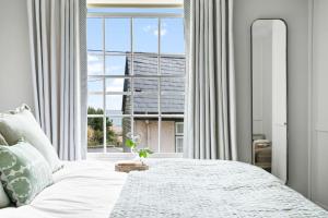 a bedroom with a bed and a large window at Poplar Cottage, Budleigh Salterton in Budleigh Salterton