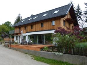 een groot houten huis met zonnepanelen op het dak bij Appartements Scharzenberger und Hinteregg in Schladming