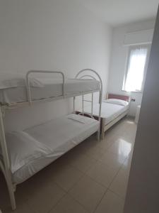 a room with two bunk beds and a window at Appartamento estivo seconda fila dal mare in Grottammare