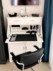 a white desk with a black chair in a room at Tiny House in Berlin Rummelsburg in Berlin