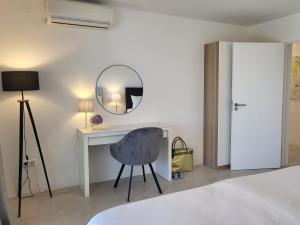 een kamer met een bureau, een stoel en een spiegel bij Modern Apartment Tara with Parking in Malinska