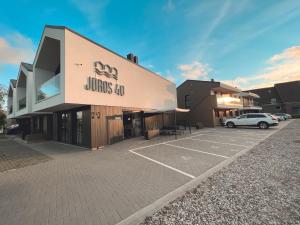 a building with a car parked in a parking lot at Jūros 40 in Šventoji