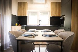 una cocina con mesa y sillas con platos y servilletas en Sunny House, en Čapljina