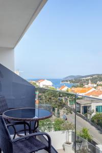 a table and chairs on a balcony with a view of the ocean at Apartments Dobrila in Hvar