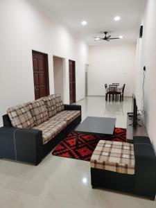 a living room with a couch and a table at Homestay Che Naa in Kuantan